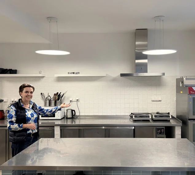 Vue d'ensemble d'une cuisine professionnelle avec plans de travails et fours à louer à Paris 20.