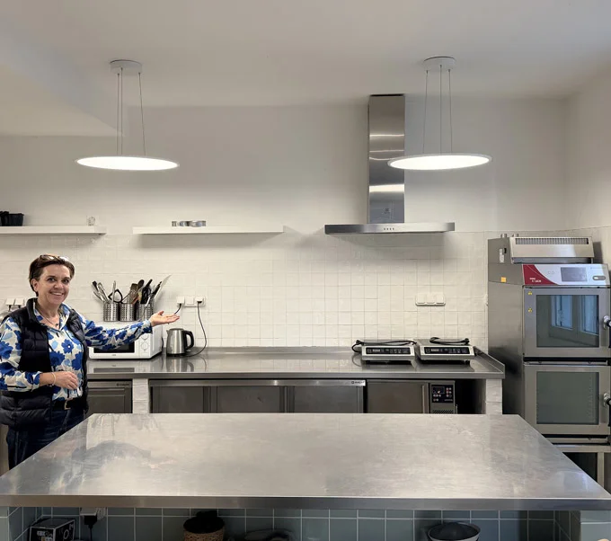 Vue d'ensemble d'une cuisine professionnelle avec plans de travails et fours à louer à Paris 20.